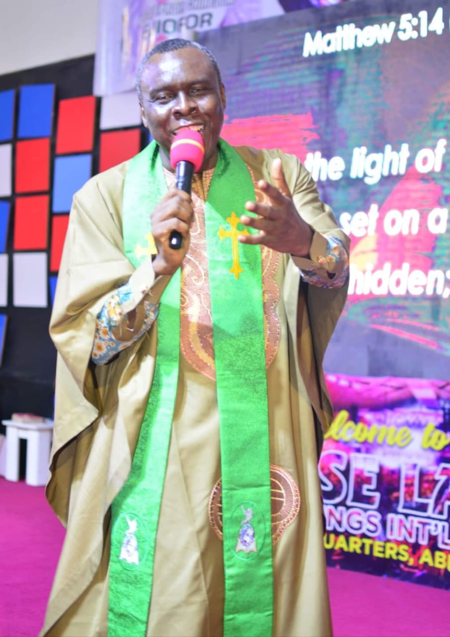 Apostle Prof. E. C. Ejiofor ministering with microphone at Praiseland Royal Springs Int'l Church