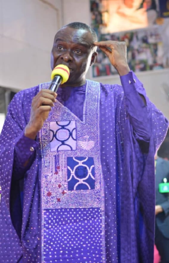 Apostle Prof. E. C. Ejiofor ministering with microphone at Praiseland Royal Springs Int'l Church