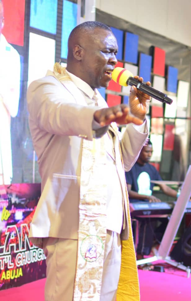 Apostle Prof. E. C. Ejiofor ministering with microphone at Praiseland Royal Springs Int'l Church