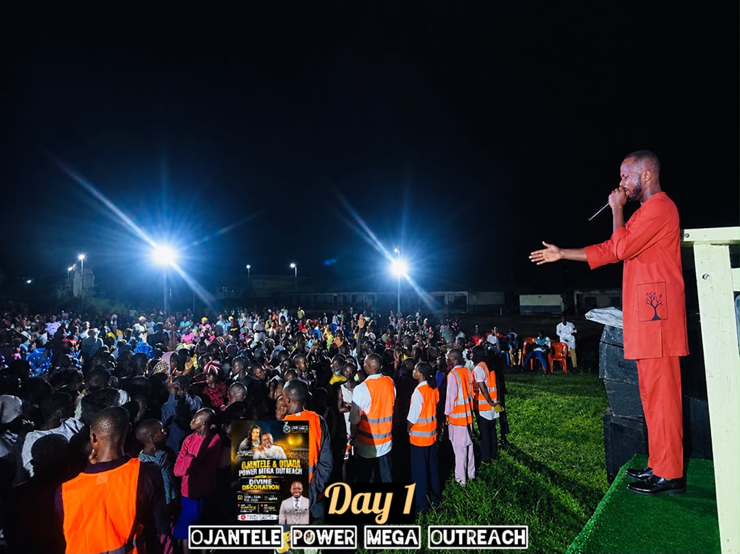 Minister addressing a huge crowd under floodlights at the Ojantele Power Mega Outreach