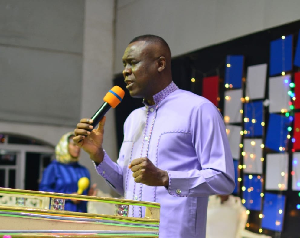 Apostle Prof. E. C. Ejiofor ministering with microphone at Praiseland Royal Springs Int'l Church