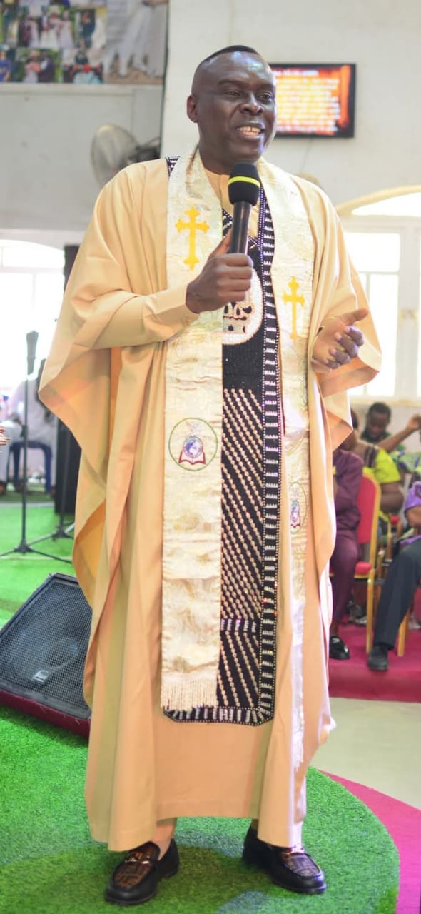 Apostle Prof. E. C. Ejiofor ministering in ceremonial robe with microphone