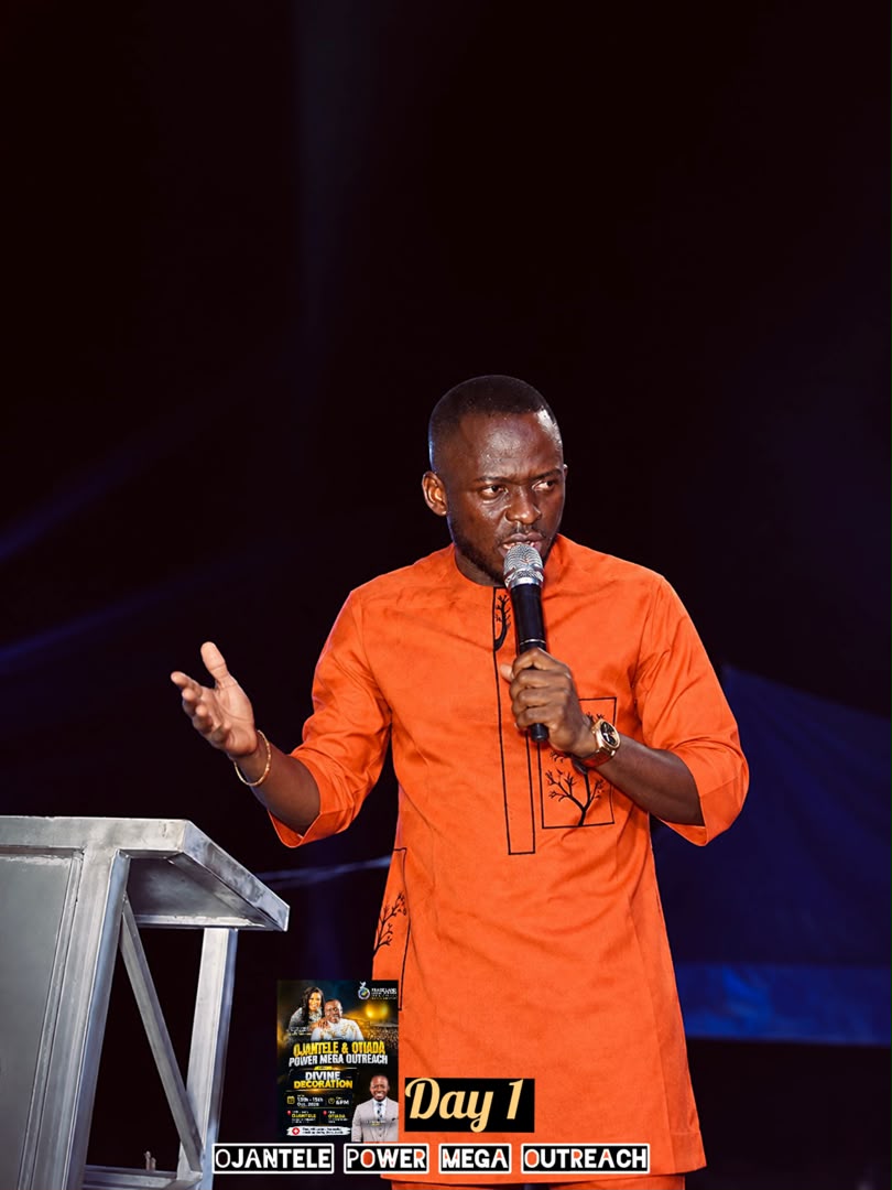 Minister in orange preaching with a microphone