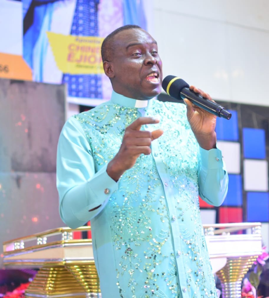Apostle Prof. E. C. Ejiofor ministering with microphone at Praiseland Royal Springs Int'l Church